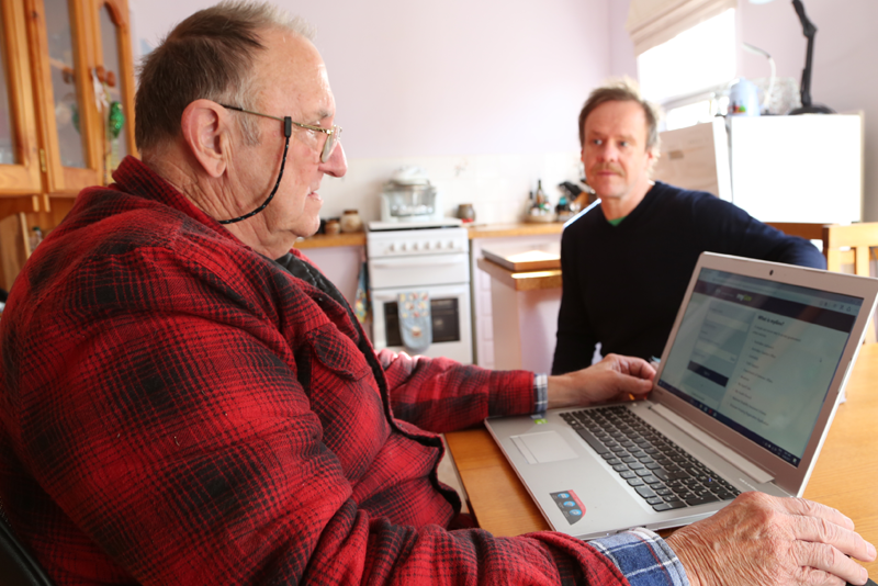 A user tests a website while a researcher looks on.