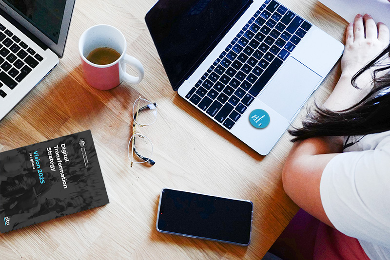 A laptop, coffee cup, glasses, mobile phone and a copy of the Strategy.