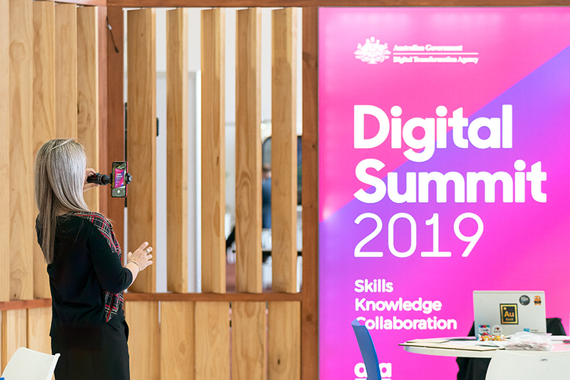 A person takes a photo at the Digital Summit.