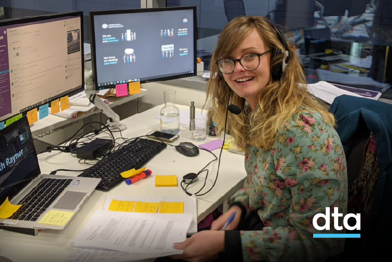 Woman sitting at her desk in front of computer screens